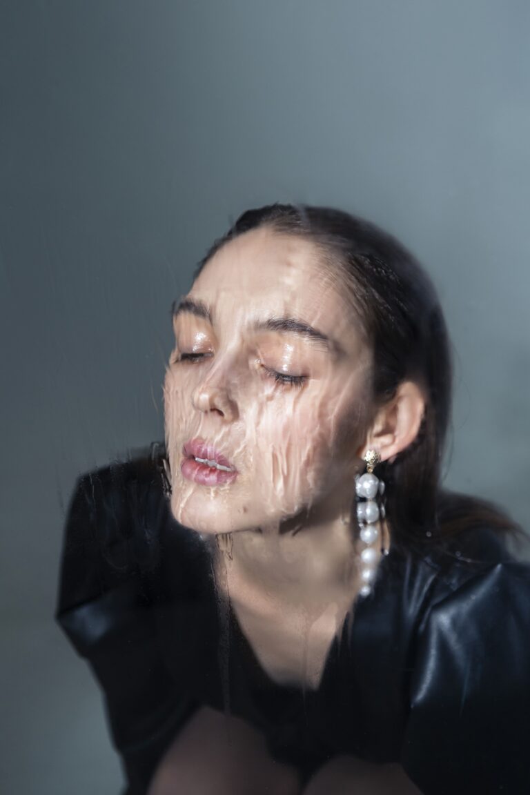 Fotografia macro em tons neutros focando na textura da pele madura e na perda de sustentação da mandíbula. Uma sobreposição gráfica sutil sugere a estrutura de colágeno sendo reestabelecida, representando a ciência da reposição volumétrica no tratamento do 'derretimento facial